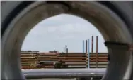  ?? DAVID J. PHILLIP — THE ASSOCIATED PRESS FILE ?? Steel pipes are seen through a roll of steel at the Borusan Mannesmann Pipe manufactur­ing facility in Baytown, Texas. President Donald Trump insists he can save U.S. jobs and factories by abandoning or rewriting trade deals, slapping taxes on imports and waging a tariff war with China, America’s biggest trading partner.