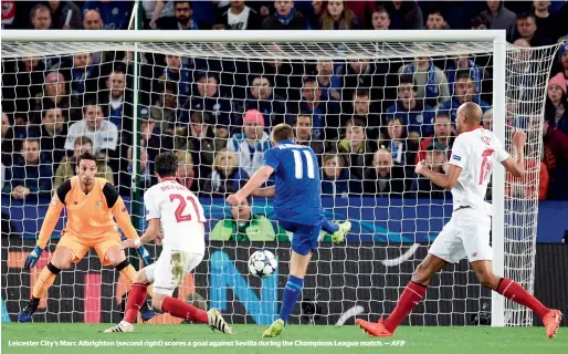  ?? — AFP ?? Leicester City’s Marc Albrighton (second right) scores a goal against Sevilla during the Champions League match.