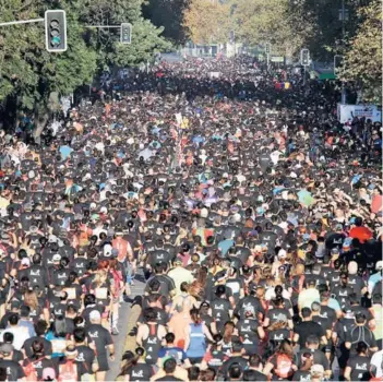  ??  ?? Una masa de gente avanza por la Alameda en el Maratón de Santiago.