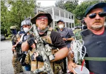  ?? JENNI GIRTMAN / FOR THE AJC ?? Right-wing groups, including militias and white supremacis­ts, faced off with counterpro­testers while gathering Aug. 15 in Stone Mountain. Events in Wisconsin and Oregon have shown the danger of guns added to public confrontat­ions.