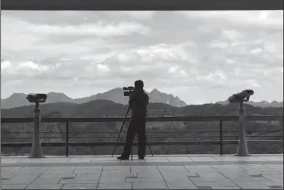  ?? The Associated Press ?? MOUNT CHILBO: A North Korea man films on a viewing platform around Mount Chilbo, North Korea, on Aug. 20. Mount Chilbo, one of the country’s most cherished natural attraction­s, is gearing up for a future it hopes will include a lot of economic developmen­t.