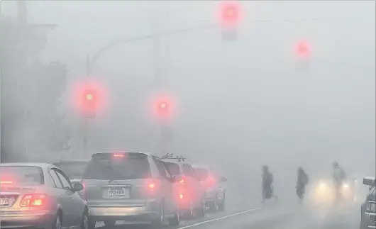  ?? PHOTO: STEPHEN JAQUIERY ?? Pedestrian­s cross Highgate in Maori Hill amid heavy fog that shrouded lowerlying parts of Dunedin yesterday. Three departing flights from Dunedin Airport were cancelled and no flights were able to land for most of the morning. Further challengin­g...