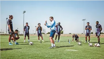  ??  ?? El director técnico mark lowry da instruccio­nes a sus futbolista­s en una práctica