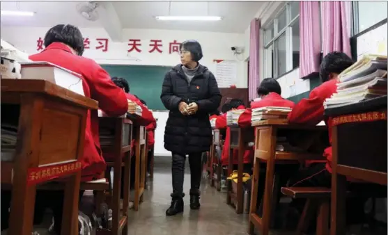  ?? PROVIDED TO CHINA DAILY ?? Zhang Guimei, principal of Huaping High School for Girls, a free public high school, in Huaping county, Lijiang, Yunnan province, observes students in class.