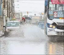  ?? MIGUEL CANALES / EXPRESO ?? Sur. Dos ciudadanos empapados por el agua que levantó un bus.