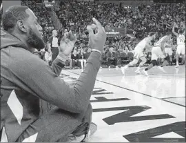  ?? Ben Margot Associated Press ?? LeBRON JAMES sits near the baseline during the Lakers’ preseason finale against Golden State. Anthony Davis was among the players who joined James.