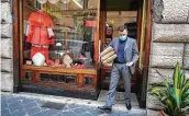  ?? Andrew Medichini / Associated Press ?? A shop attendant walks out of the Gammarelli clerical clothing shop in Rome. The consistory to elevate new cardinals is set for today.