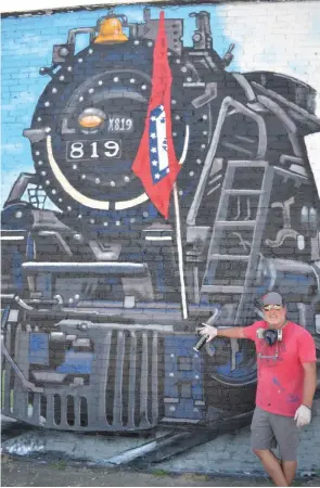  ?? (Special to The Commercial/Richard Ledbetter) ?? Traveling artist Jason White stands before the image of the 819 steam engine in his first Fordyce mural.