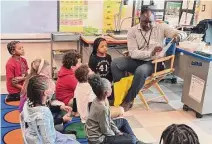  ?? Chatwan Mongkol/Hearst Connecticu­t Media ?? A volunteer from Yale New Haven Health reads to students at Barack Obama University Magnet School in New Haven Friday.