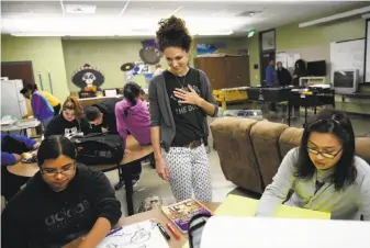  ?? Michael Short / Special to The Chronicle ?? Teacher Eve King (center) looks on as students Berenice Rosales (left) and Brandon Ng work on anti-gun-violence posters at the Academy, where students plan to walk out on Wednesday.