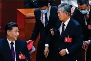  ?? ?? EXIT: Xi Jinping, left, looks on as Hu Jintao is led away