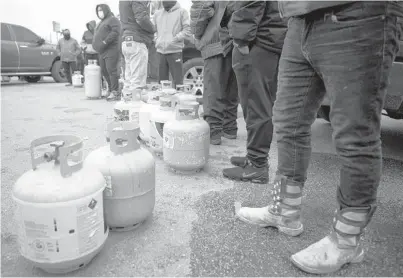  ?? BRETT COOMER/HOUSTON CHRONICLE ?? Texans line up to fill their empty propane tanks last week in Houston. Severe winter storms plunged Texas and other states into a deep freeze that caused power outages in millions of homes and businesses.