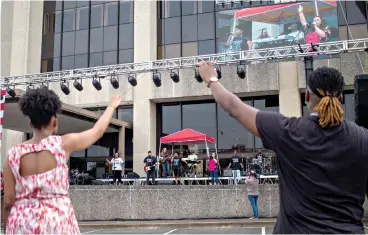  ?? Photo by Sara Vaughn ?? ■ Attendees raise their hands in worship Saturday during Freedom Fest at the former Regions bank building in downtown Texarkana, Arkansas. The event also featured a snow cone truck, T-shirt stand and basketball hoops.