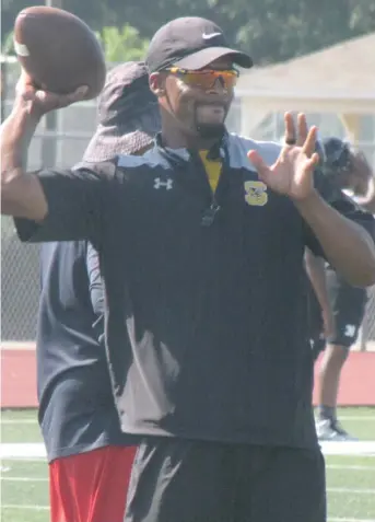  ?? (Photo by Danny P. Smith, SDN) ?? Starkville High School head football coach Chris Jones tosses a football Monday during his first practice of the preseason with the Yellowjack­ets.