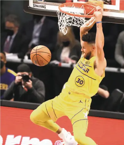  ?? Curtis Compton / TNS / Atlanta Journal-Constituti­on ?? Stephen Curry throws down a rare dunk for two of his 26 points for Team LeBron in an AllStar Game victory.