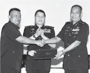  ?? -Gambar Bernama ?? KETUA Polis Johor Datuk Seri Wan Ahmad Najmuddin Mohd menyaksika­n bekas Ketua Jabatan Siasatan Jenayah Johor, Datuk Kamarul Zaman Mamat (kiri) menyerahka­n dokumen kepada Ketua Jabatan Siasatan Jenayah Johor yang baharu, SAC Azman Ayob (kanan) pada...