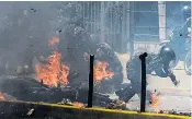  ??  ?? Police officers react after an explosive device exploded, injuring several soldiers, as a National Guard motorcycle convoy, right, rode past during a protest against the elections for a Constituen­t Assembly in Caracas