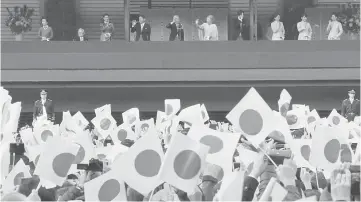  ??  ?? Emperor Akihito (fifth left) and Empress Michiko with other royal family members wave to well-wishers during a public appearance for New Year celebratio­ns at the Imperial Palace. — Reuters photo