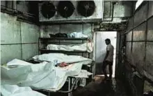  ?? AFP ?? Too many to handle A medic in a cold storage unit at a morgue in New Delhi. Several thousand bodies fill the city’s morgues after being discovered in public spaces every year.