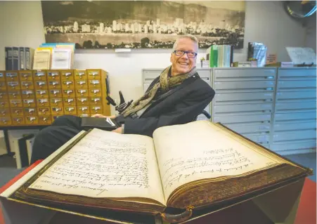  ?? ARLEN REDEKOP ?? Transcribi­mus founder and former mayor Sam Sullivan displays handwritte­n budget minutes from 1897 inside the Vancouver Archives.