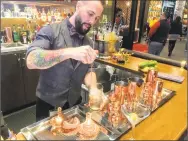  ?? Joe Amarante / Hearst Connecticu­t Media ?? Dan Hickok prepares drinks with copper bar tools at the Lobby Bar.