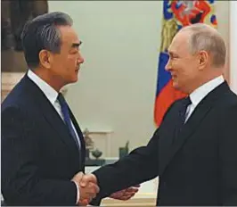  ?? FOTOS: AFP ?? SALUDO. Wang Yi, enviado de Xi Jinping, junto a Vladimir Putin.