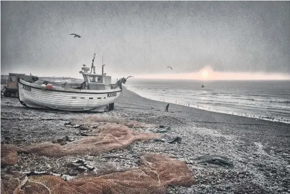  ??  ?? The scene after a wintry snow shower fell over The Stade fishing beach in Hastings, East Sussex, yesterday. Cold conditions are expected to continue throughout the week, with temperatur­es falling as low as 7F (-14C)