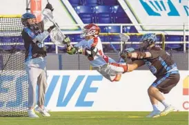  ?? PAUL W. GILLESPIE/CAPITAL GAZETTE ?? Team Fire’s Rob Pannell goes airborne on a goal attempt but Team Ice goalie Dillon Ward makes a save in the first quarter of the Major League Lacrosse All-Star Game.