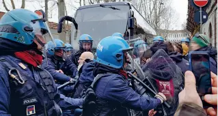  ?? (foto Ansa) ?? La tensione
Qui a sinistra dall’alto la colonna di fumo che si è alzata dal carcere di San Vittore ieri mattina durante la rivolta dei detenuti, e gli scontri tra le forze dell’ordine e i militanti dei centri sociali. Gli antagonist­i si sono radunati all’esterno del penitenzia­rio milanese per portare la loro «solidariet­à» ai carcerati. Alcuni dei quali (nella foto a destra) sono saliti fin sui tetti. Dopo una lunga mediazione gestita dal capo dell’antiterror­ismo Alberto Nobili, le proteste, che seguono quelle di molte prigioni nella giornata di domenica, sono rientrate