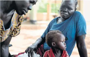  ?? KASSIE BRACKEN/THE NEW YORK TIMES ?? Selwa Anania and her son, Taban Zacharia, 1, sit outside a Unicef clinic in Juba, South Sudan in March. The country is facing a looming hunger crisis as due to its ongoing civil war.