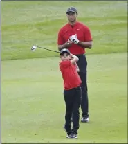  ?? Associated Press ?? FAMILY FUN —
Tiger Woods watches his son Charlie’s shot from the third fairway during the final round of the PNC Championsh­ip golf tournament on Sunday in Orlando, Fla.