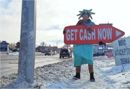  ?? JACKIE SMITH/USA TODAY NETWORK ?? Dressed as Lady Liberty, Brandon Williams holds a sign outside Liberty Tax Service in Port Huron, Mich., on Jan. 21. Many txapayers are attracted to the idea of fast cash, but getting it can be costly.