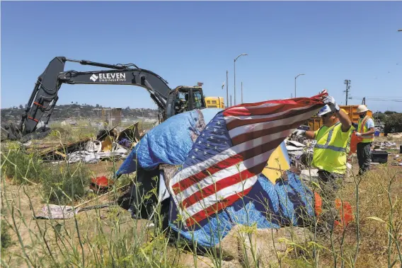  ?? Photos by Amy Osborne / Special to The Chronicle ?? An eïcavator clears an area in Camp Cormorant during a move Tuesday from Dunphy Park to !arinship Park enforced by Sausalito police.