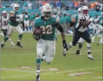  ?? LYNNE SLADKY - THE ASSOCIATED PRESS ?? Miami Dolphins running back Kenyan Drake (32) runs for a touchdown during the second half of an NFL football game against the New England Patriots, Sunday, Dec. 9, 2018, in Miami Gardens, Fla. The Dolphins defeated the Patriots 34-33.