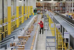  ?? (Lucas Jackson/Reuters) ?? A WORKER CLEARS a conveyor belt inside an Amazon fulfillmen­t center in Robbinsvil­le, New Jersey.