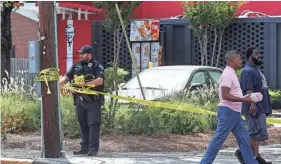  ?? RICHARD BURKHART/SAVANNAH MORNING NEWS ?? A Savannah Police officer removes crime scene tape at the KFC on West Gwinnett Street following a shooting in 2023.