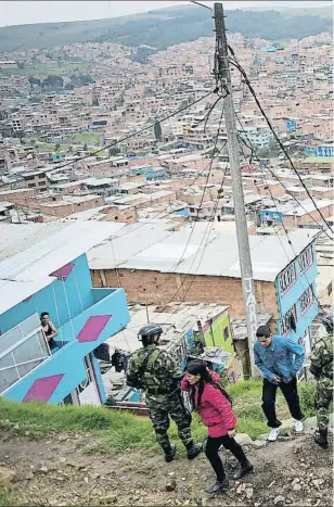  ??  ?? Soldados de guardia en un alto del gigantesco
suburbio de Ciudad Bolívar, en el sur de la gran
Bogotá