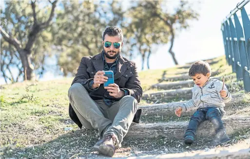  ?? DREAMSTIME ?? With phones in the picture, parenting has become more physically present, “yet only fitfully present emotionall­y,” Erika Christakis writes in the Atlantic.