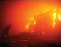  ?? UKRAINIAN STATE EMERGENCY SERVICE HANDOUT PHOTO VIA AFP ?? BLAZING BATTLE
A firefighte­r tries to put out a building fire caused by falling debris following a massive drone attack targeting Ukraine’s capital Kyiv on Sunday, May 28, 2023.