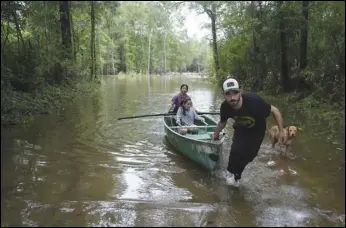  ?? ASSOCIATED PRESS ?? Alvaro Trevino pulls a canoe with Jennifer Tellez and Ailyn, 8, after they checked on their home on Sunday in Spendora, Texas. The family has lived on the property in a rental trailer for two years. “It’s really bad,” said Tellez, who says they stayed dry during the most recent flooding in February.