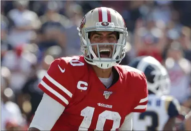  ?? JOHN LOCHER — THE ASSOCIATED PRESS ?? 49ers quarterbac­k Jimmy Garoppolo celebrates after scoring a rushing touchdown against the Los Angeles Rams during the second half of Sunday’s 20-7victory at Los Angeles Memorial Coliseum.