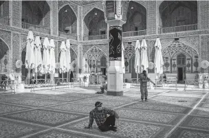  ?? IVOR PRICKETT/NEW YORK TIMES ?? Pilgrims in the courtyard of the Shrine of Imam Ali in Najaf, Iraq, earlier this month. Oil revenues, the Iraqi government’s main source of income, have plummeted as the world price of oil has crashed, and the government has resorted to asking for donations to help it weather the pandemic.