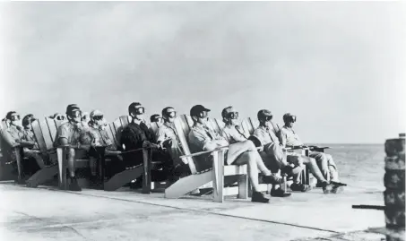  ?? Time Life Pictures / The LIFE Picture Collection / Getty Images ?? High-ranking military personnel in goggles are illuminate­d by the massive flare from a nuclear bomb detonation as they observe at the old Atomic Energy Commission's Pacific Proving Ground during the time when above-ground testing was conducted.