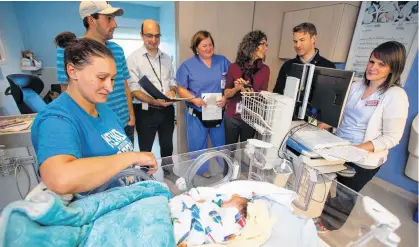  ?? RYAN TAPLIN • THE CHRONICLE HERALD ?? A medical assessment team visits baby Nathan Mazerolle and his family in the IWK Health Centre's neonatal intensive care unit. From left are Nathan's mom Rachelle Henrie of Bouctouche, N.B., dad Julien Mazerolle, Dr. Jon Dorling, head of neonatalpe­rinatal medicine, nurse practition­er Arthena MacDonald, neonatal dietitian Joyce Ledwidge, pharmacist Andrew Veysey and charge nurse Bev Fiddler.