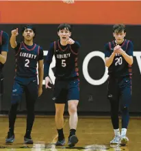  ?? KINTZEL/THE MORNING CALL RICK ?? Liberty’s Blake Hargrove (2), Jacob Pukszyn (5) and Caden Vermuelen cheer on a teammate March 1 after a made free throw in overtime during a District 11 boys basketball doublehead­er at Easton Area Middle School.