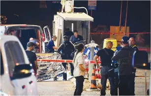  ?? ?? SECURITY AND rescue personnel work at the scene of the shooting attack at the entrance to Ariel early yesterday morning.