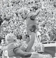  ?? Curtis Compton / Associated Press ?? Georgia’s Solomon Kindley (66) hoists teammate Jeremiah Holloman after Holloman’s first TD catch.