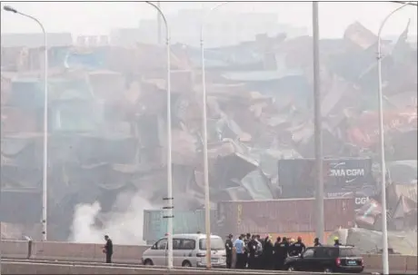  ?? NG HAN GUAN — THE ASSOCIATED PRESS ?? Chinese emergency crew members survey the site of an explosion in northeaste­rn China’s Tianjin municipali­ty Saturday. New explosions and fire rocked the Chinese port city on Saturday, where one survivor was pulled out.