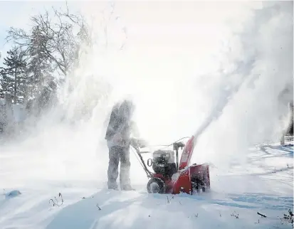  ?? JENN ACKERMAN THE NEW YORK TIMES FILE PHOTO ?? A man blows snow from the sidewalk during frigid weather conditions. Residents living east of both Lake Erie and Lake Ontario could be facing extreme lake-effect snow with accumulati­ons in some areas of up to 40 inches or more than 100 centimetre­s