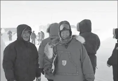  ?? Photo by RB Smith ?? SHAKTOOLIK CHECKERS— Lynn Takak and Iditarod Checker Gary Bekoalok wait for Iditarod teams to arrive in Shaktoolik on Sunday, March 13.